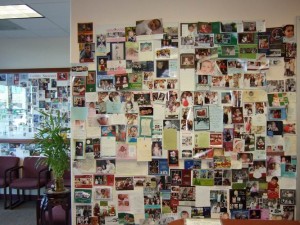 Fertility Success with Dr. Lee with acupuncture and herbal treatments. front of reception wall filled with baby photos.